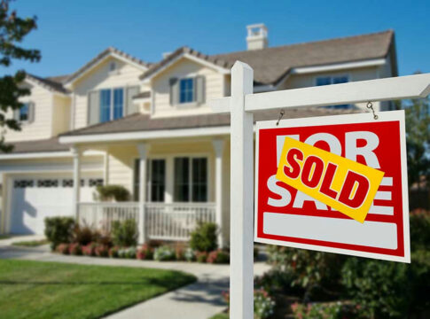 House with For Sale sign labeled Sold.