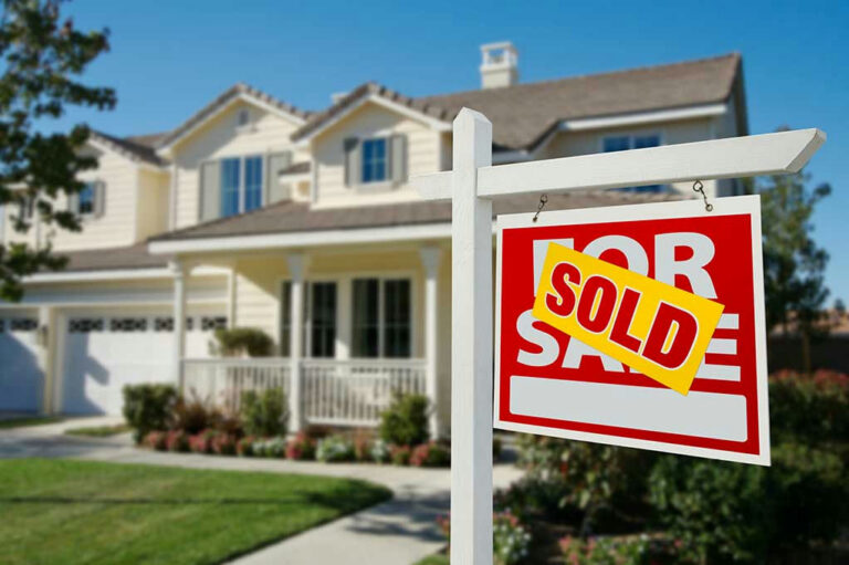 House with For Sale sign labeled Sold.