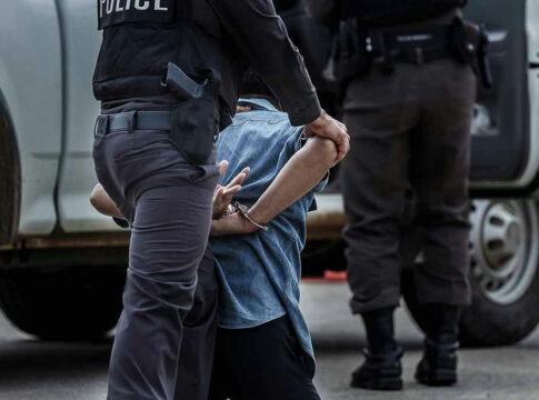 Police officer arresting and handcuffing a person.