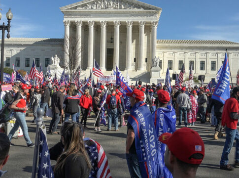People gathered with flags in front of building
