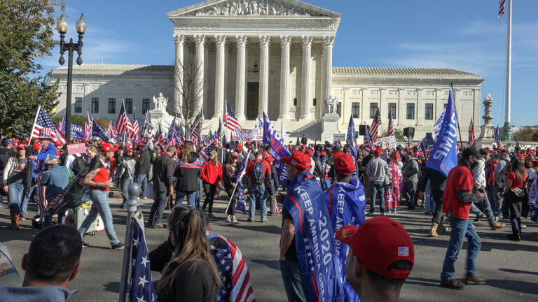 People gathered with flags in front of building