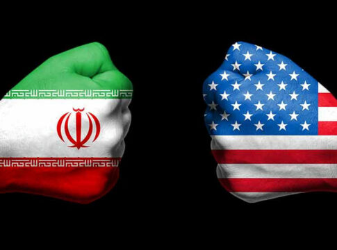 Two fists painted with Iran and USA flags.