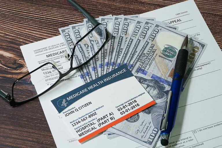 Medicare card with cash, documents, glasses, and pen.