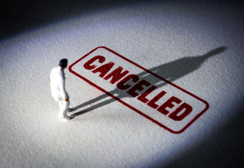 miniature figure standing near a large cancelled stamp