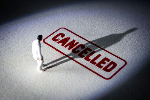 miniature figure standing near a large cancelled stamp