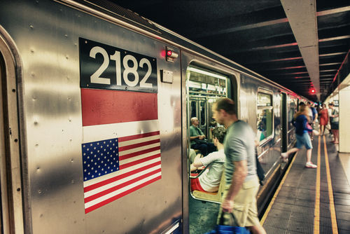 A busy subway platform with a train pulling in.