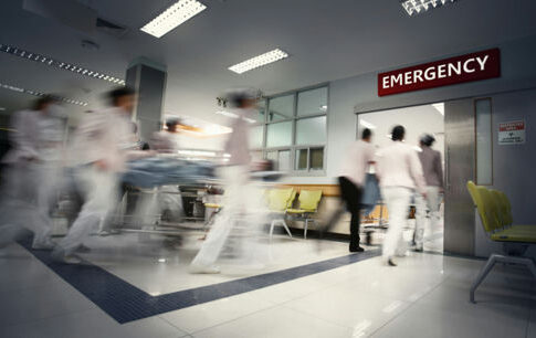 Medical staff rushing patient on stretcher in emergency room.
