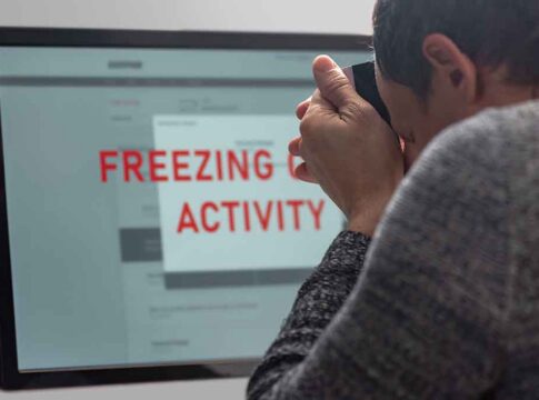 Person photographing computer screen with warning message