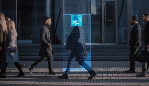 A digital overlay of a persons face on a pedestrian walking in an urban environment