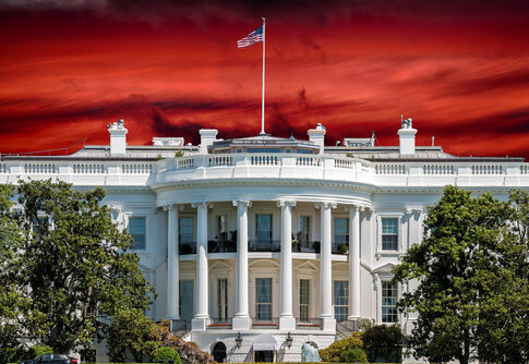 The White House with an American flag against a dramatic red sky